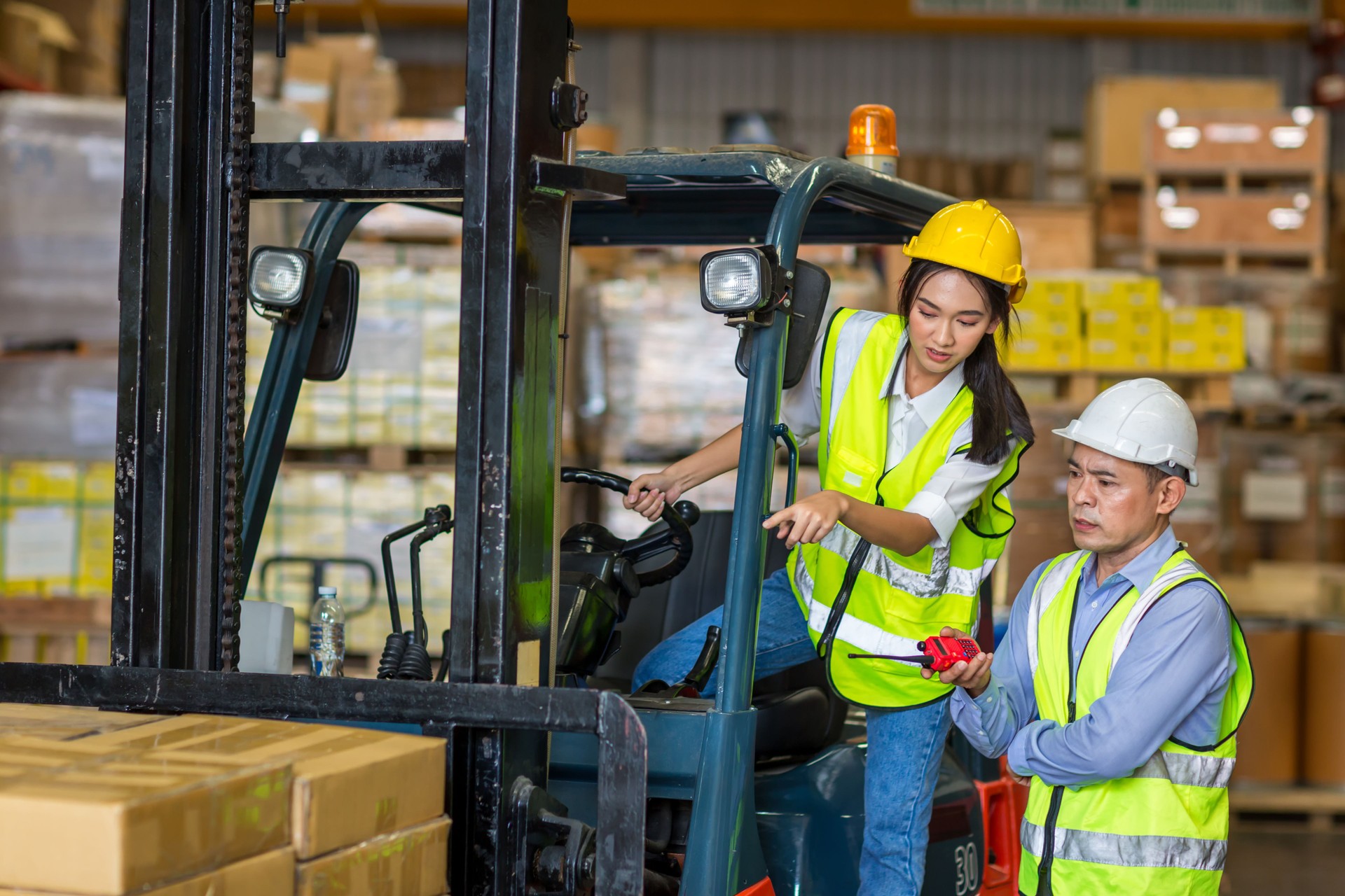 Worker at forklift driver working in industry factory logistic ship. Woman forklift driver in warehouse area.