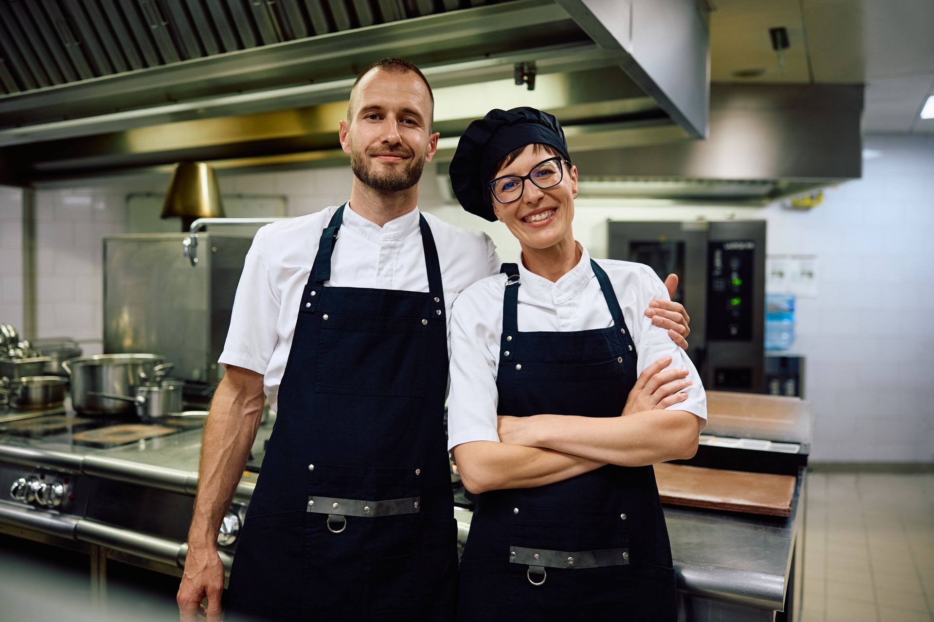 Portrait of happy chefs in the kitchen at restaurant looking at camera.